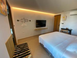 a bedroom with a large white bed and a tv at THE CELESTRAIL - Apartment - Check-In by Appointment Only - Non-hotel - Onnut BTS in Bangkok