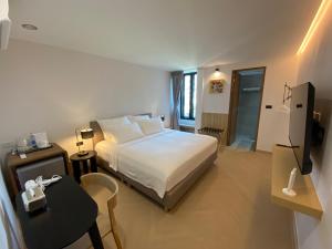 a hotel room with a bed and a table and a television at THE CELESTRAIL - Apartment - Check-In by Appointment Only - Non-hotel - Onnut BTS in Bangkok