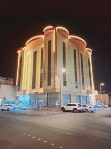 a large building with cars parked in a parking lot at شقق البحر الأزرق المخدومه in Nimrān