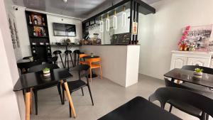 a restaurant with black tables and chairs and a bar at Vicente Aguirre Rooms in Boracay