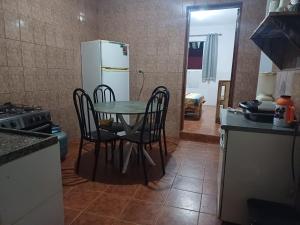 a kitchen with a table and chairs and a refrigerator at Mirante do Sol in São Thomé das Letras +3 photos
