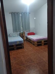 a room with two beds and a window at Mirante do Sol in São Thomé das Letras