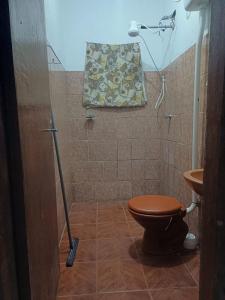 a bathroom with a toilet and a mop at Mirante do Sol in São Thomé das Letras