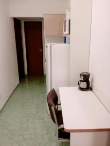 a kitchen with a white table and a refrigerator at Flats Via Mar in Macaé +5 photos