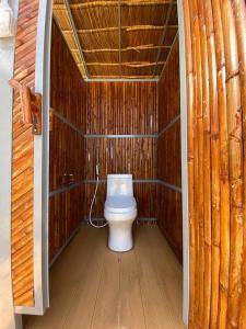 a bathroom with a toilet in a wooden cabin at Breathe Wild in Phumĭ Pu Rôdêt Leu
