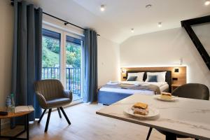a bedroom with a bed and a table with a piece of cake at Apartamenty Pieniński Potok w Centrum Szczawnicy in Szczawnica