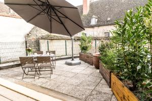 a patio with a table and chairs and an umbrella at L'Appartement in Beaune