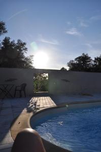a swimming pool in a backyard with the sun shining at Domaine de Nidolères in Tresserre