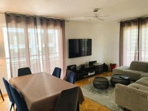 un salon avec une table et un canapé dans l'établissement LE PARADIS - 2 chambres, balcon, parking, à Boulogne-Billancourt