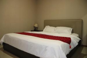 a bedroom with a large bed with a red blanket at Thamrin Residence City Home in Jakarta