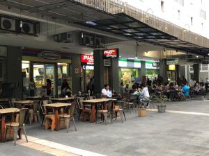a group of people sitting at tables outside a restaurant at Thamrin Residence City Home in Jakarta