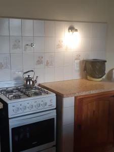 a kitchen with a stove with a tea kettle on it at El Quincho de los Abuelos in Trevelín