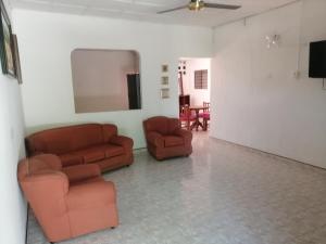 a living room with two chairs and a mirror at casa la magdalena in La Dorada