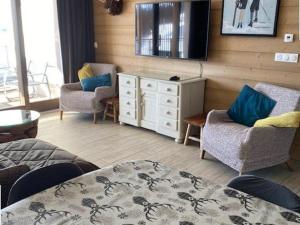 a living room with a tv and two chairs and a table at Luxueux 3 pièces aux Arcs 1600 avec piscine et spa, wifi, parking couvert, skis aux pieds - FR-1-461A-16 in Arc 1600