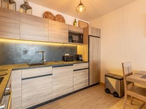 a kitchen with wooden cabinets and a sink and a table at Luxueux 3 pièces aux Arcs 1600 avec piscine et spa, wifi, parking couvert, skis aux pieds - FR-1-461A-16 in Arc 1600