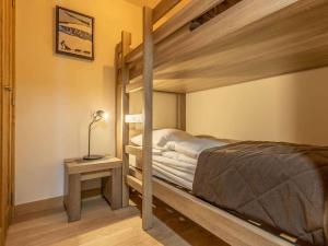 a bedroom with a bunk bed and a side table at Luxueux 3 pièces aux Arcs 1600 avec piscine et spa, wifi, parking couvert, skis aux pieds - FR-1-461A-16 in Arc 1600 +28 photos