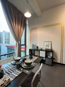 una sala da pranzo con tavolo e piatti di Breeze Cottage@Empire Damansara a Petaling Jaya
