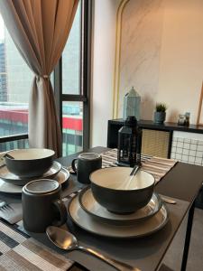 un tavolo con ciotole e cucchiai sopra di Breeze Cottage@Empire Damansara a Petaling Jaya