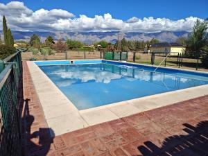 a swimming pool with blue water and mountains in the background at Las Masias de Nono in Nono