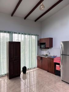 a kitchen with wooden cabinets and a refrigerator at Apartamento Colibri in Parrita +13 photos