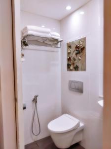a white bathroom with a toilet and a sink at KoenoKoeni Boutique Hotel in Bandung +24 photos