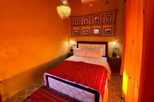 una camera con un letto in una stanza con pareti arancioni di Nomadic Birdway a Imiter