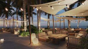 un patio con tavolo, sedie e ombrelloni di Secrets Saint Lucia Resort & Spa - All Inclusive a Gros Islet