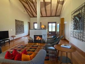 sala de estar con chimenea, sillas y mesa en Yarrabandai Creek Homestead, en Ootha