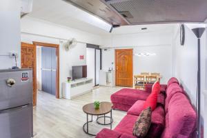 a living room with a red couch and a table at Hagone-Condotel Pattaya in Pattaya South