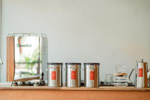 a row of canisters sitting on a wooden shelf at 1950 Luangprabang Hostel in Luang Prabang
