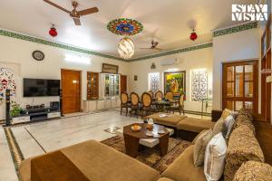 a living room with a couch and a table at Udaikot by VEO - Part of StayVista in Udaipur