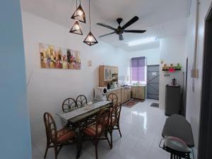 a kitchen with a table and chairs and a ceiling fan at Adempuri homestay in Jitra
