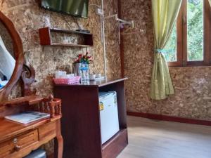 eine Küche mit einer Theke und einem Kühlschrank im Zimmer in der Unterkunft Tree Tops River Huts in Khao Sok
