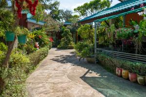 a walkway in front of a house with flowers at Thai Smile Bungalows in Ko Lanta