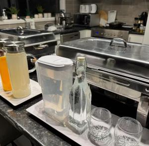 a kitchen counter with two glasses and a bottle of water at Mahzan Private Room 2 in Truganina