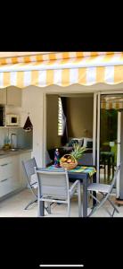 a table and chairs in a kitchen with an awning at Tidousè Matnik in Sainte-Anne