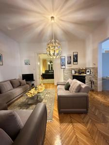 a living room with couches and a chandelier at Apartment Leyla in Sarajevo