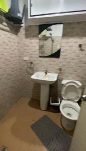 ein Badezimmer mit weißer Toilette und Waschbecken in der Unterkunft Condominium Primavera Uptown in Cagayan de Oro