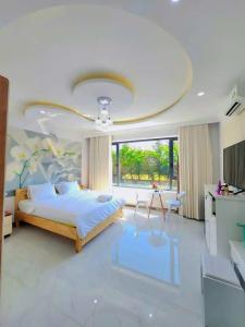 a bedroom with a large bed and a large window at Apec Sunsea Homestay in Liên Trì (3)