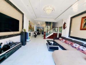 a living room with a couch and a flat screen tv at Apec Sunsea Homestay in Liên Trì (3)