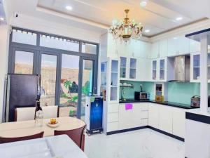 a kitchen with a table and a chandelier at Apec Sunsea Homestay in Liên Trì (3)