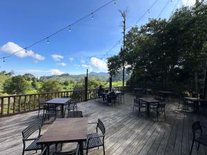 a wooden deck with tables and chairs on it at Puncak Tawa Park in Tengahgirang +27 photos