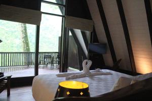 a bedroom with a bed and a balcony with a view at Puncak Tawa Park in Tengahgirang