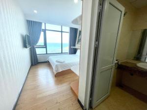 Cet appartement comprend une chambre avec un lit et une fenêtre. dans l'établissement Beachfront Hon Chong Holtel & Apartment, à Nha Trang