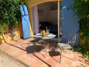 a table and chairs sitting on a patio at Sous les pins parasols in Vidauban
