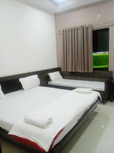 due letti in una stanza con finestra di Apple Resort & Restaurant a Jodhpur