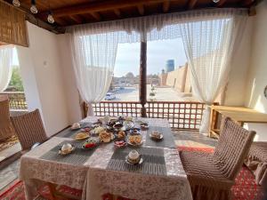 a table with food on it in a room with a window at MIRONSHOX GuEST HOUSE in Khiva