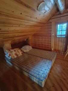 a bedroom with a bed in a log cabin at Kalliorinteen Mökit Ruskapirtti in Töysä +12 photos