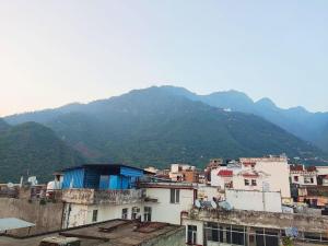 a group of buildings with mountains in the background at Hotel Ishaan International Near Yatra Parchi Counter 2 in Katra