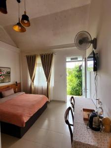 a bedroom with a bed and a table and a window at La nha Homestay in Da Lat